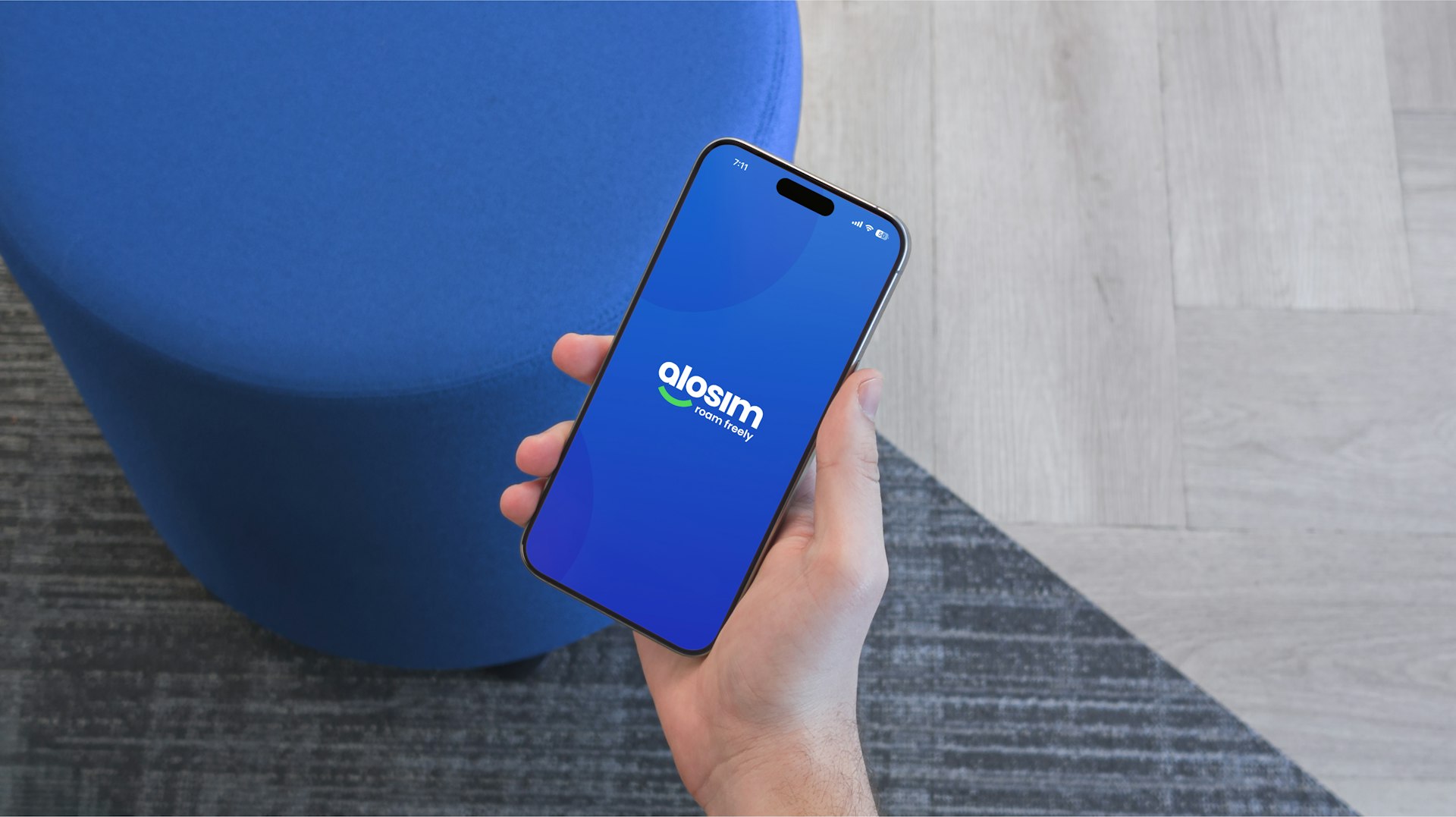A hand holds a phone showing a blue screen.